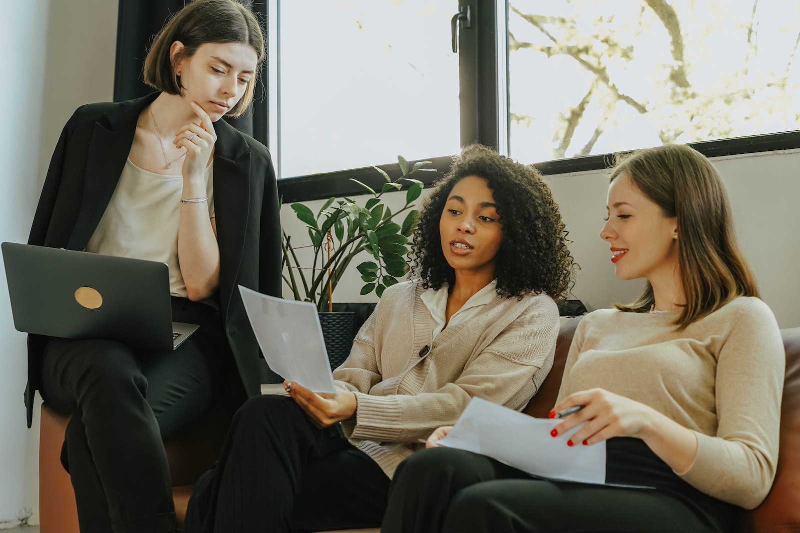 Women Sitting on a Sofa While Talking Business